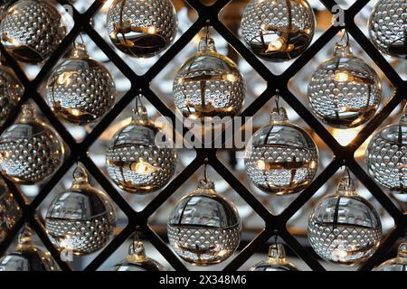 sfere di vetro trasparenti appese in diamanti a reticolo metallico, decorazioni ornamentali Foto Stock