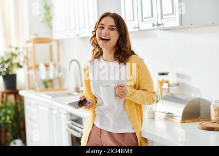 Donna di mezza età con caffè in cucina. Foto Stock