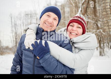 Ritratto a mezza lunghezza di un uomo e una donna sorridenti nel parco invernale. Foto Stock