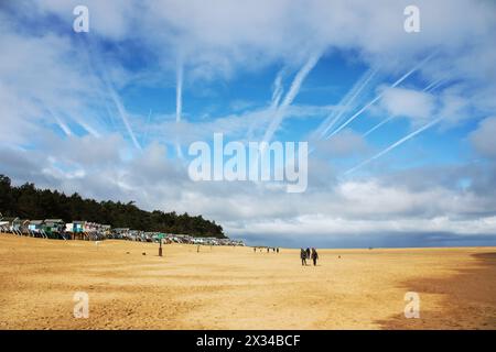 Spettacolare scenario di spiaggia da Wells NEXT the Sea, Norfolk. Le tracce di vapore della RAF esercitano prove nell'enorme cielo blu Foto Stock
