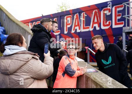 Harvey Barnes (a destra) del Newcastle United posa per le fotografie con un tifoso in vista della partita di Premier League a Selhurst Park, Londra. Data foto: Mercoledì 24 aprile 2024. Foto Stock