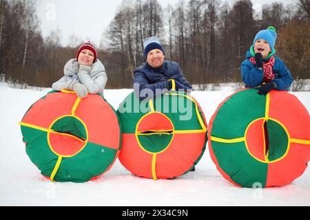 Madre, padre e figlio posano con i tubi di neve in inverno, concentratevi sui genitori Foto Stock