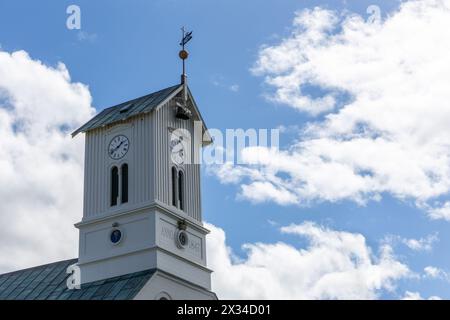 Cattedrale di Reykjavik (Domkirkjan i Reykjavik), una chiesa neoclassica cattedrale campanile con tetto verde, orologio e banchi meteorologici contro il cielo blu, ghiaccio Foto Stock