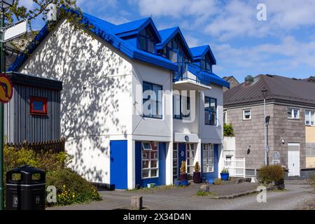 Moderna casa islandese con tetto a timpano blu, facciata in pietra bianca e finestre dormitori nel quartiere residenziale di Reykjavik, Islanda. Foto Stock