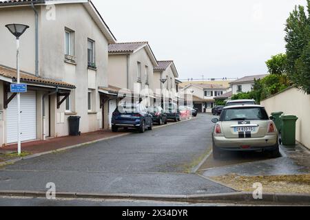 Bordeaux, Francia - 26 aprile 2023: Una fila di case con varie auto parcheggiate davanti a loro in una strada residenziale. Foto Stock