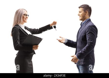 Donna professionale che dà le chiavi di un'auto a un uomo isolato su sfondo bianco Foto Stock