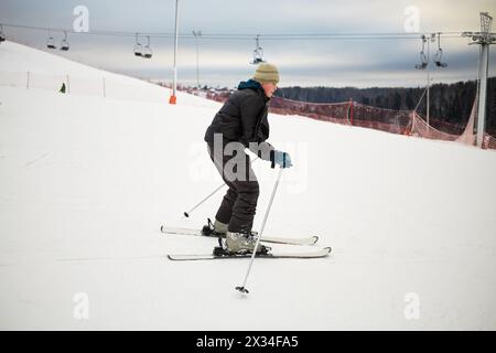 Sci da ragazzo adolescente su piste innevate presso la stazione sciistica. Foto Stock