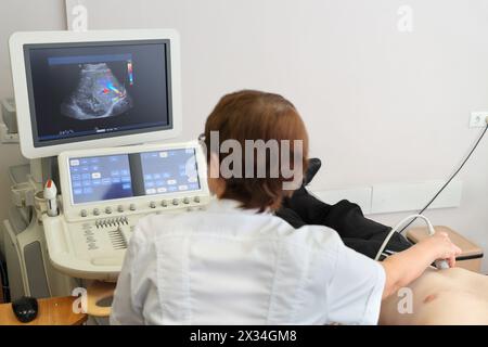 MOSCA - 31 agosto 2015: Il medico esamina il paziente utilizzando l'ecografia, nella clinica multidisciplinare CELT, vista posteriore Foto Stock