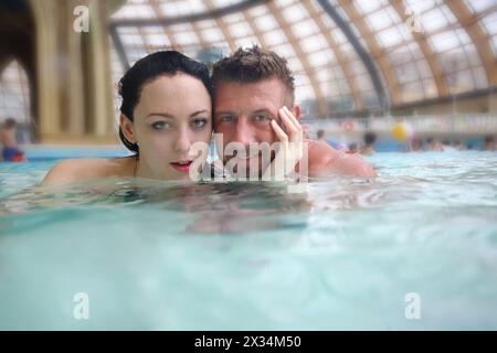 Uomo e donna che nuotano nella piscina dell'acquapark Foto Stock