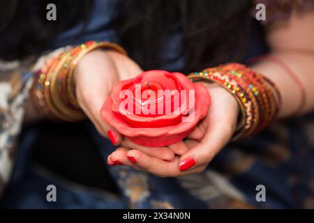 Le mani delle donne con braccialetti tengono candele spente sotto forma di rose, primo piano Foto Stock