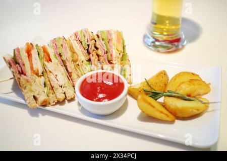 Panini con prosciutto, salsa rossa e patate fritte sul piatto del tavolo Foto Stock