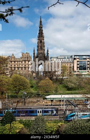 Treni seduti alla stazione di Waverley con lo Scott Monument e gli East Princes Street Gardens sullo sfondo. Foto Stock