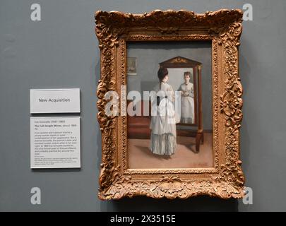 La Psyché raffigura una semplice stanza contenente un divano, un quadro sulla parete e uno specchio a figura intera, chiamato une psyché in francese. Una giovane donna si guarda allo specchio, afferrando un piccolo fiore rosso - l'unico punto di colore brillante in questo dipinto attenuato. Il suo abito è lavorato in modo deciso e il suo viso è delicatamente modellato in tonalità di grigio marrone che si abbinano alla stampa sul muro. Questo sottile monocromatico ricorda la stampa dei primi lavori di Manet sul muro, ma sembra essere unico nel suo. La modella è la sorella minore di Gonzalès Jeanne, che ha posato regolarmente per Gonzalès. Foto Stock