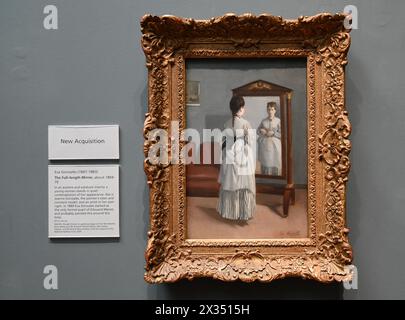 La Psyché raffigura una semplice stanza contenente un divano, un quadro sulla parete e uno specchio a figura intera, chiamato une psyché in francese. Una giovane donna si guarda allo specchio, afferrando un piccolo fiore rosso - l'unico punto di colore brillante in questo dipinto attenuato. Il suo abito è lavorato in modo deciso e il suo viso è delicatamente modellato in tonalità di grigio marrone che si abbinano alla stampa sul muro. Questo sottile monocromatico ricorda la stampa dei primi lavori di Manet sul muro, ma sembra essere unico nel suo. La modella è la sorella minore di Gonzalès Jeanne, che ha posato regolarmente per Gonzalès. Foto Stock