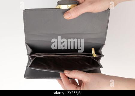 Una borsa vuota nelle mani delle donne. Il concetto di povertà. Una donna apre un portafoglio vuoto. Foto Stock