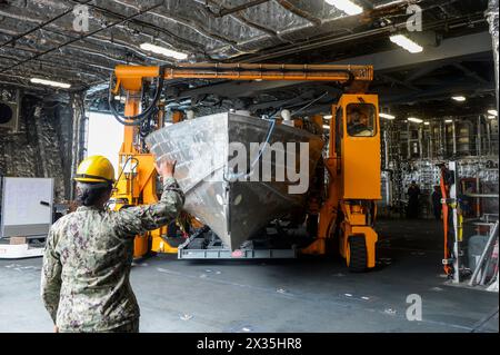 Boatswain Mate 3rd Class Deora Ledmitiituiasosopo (sinistra), dirige il trasporto di una nave di superficie senza equipaggio nella baia della missione a bordo della nave da combattimento litorale variante indipendenza USS Canberra (LCS 30) durante il primo imbarco del pacchetto missione Mine Countermeasure (MCM), 23 aprile. Il pacchetto missione MCM è una suite integrata di sistemi e sensori marittimi senza equipaggio che individua, identifica e distrugge le mine nei litorali, aumentando allo stesso tempo la distanza di stallo della nave dall'area di minaccia. Le navi da combattimento Littoral sono combattenti di superficie veloci, con equipaggio ottimale e su misura per la missione Foto Stock