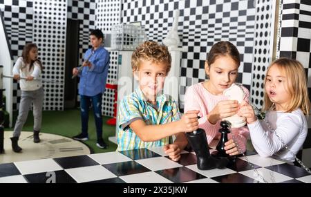 Avventura emozionante per i bambini positivi nella stanza di ricerca degli scacchi Foto Stock