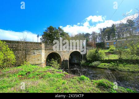 Il ponte principale del villaggio Blanchland di Northumberland con cielo blu e nuvole bianche Foto Stock