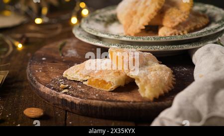 Una pasta a mezzaluna il cui ripieno è costituito da uova e mandorle avvolte in un impasto croccante, tagliato artigianalmente e cosparso di zucchero. Foto Stock