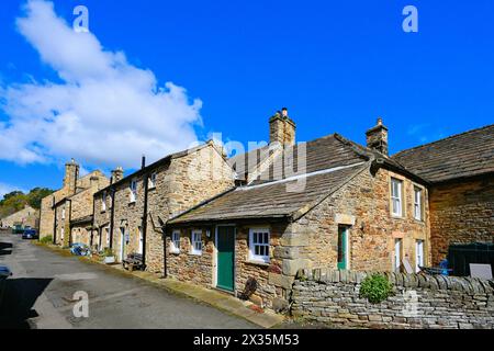 Una strada laterale attraverso il villaggio Blanchland di Northumberland che mostra lavori in pietra e spesse ardeie del tetto con cielo blu e nuvole bianche Foto Stock