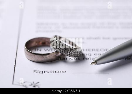 Contratto di matrimonio, penna e fedi nuziali, primo piano Foto Stock