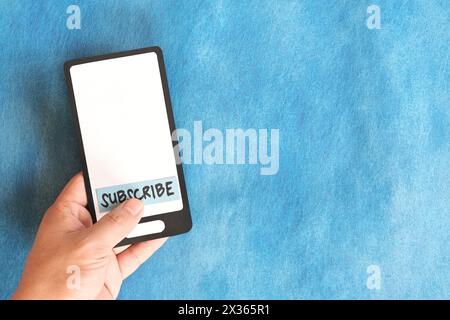 Utente che fa clic sulla parola iscriviti sul telefono cellulare. Foto Stock
