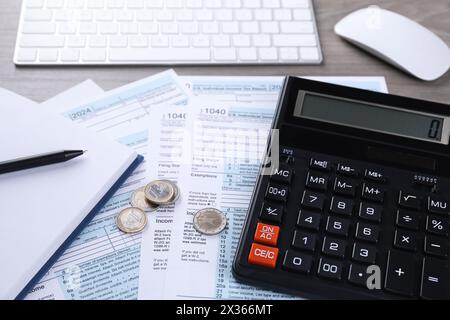 Contabilità fiscale. Calcolatrice, documenti, monete, tastiera e cancelleria sul tavolo, primo piano Foto Stock