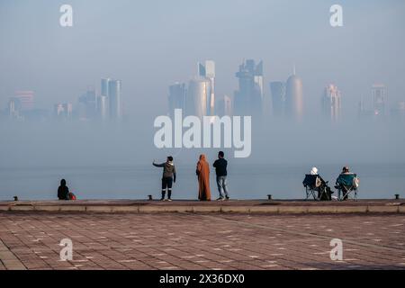 Foggy Doha Corniche nelle prime ore del mattino d'inverno. Skyline di Doha nella nebbia Foto Stock