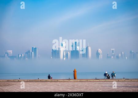 Foggy Doha Corniche nelle prime ore del mattino d'inverno. Skyline di Doha nella nebbia Foto Stock