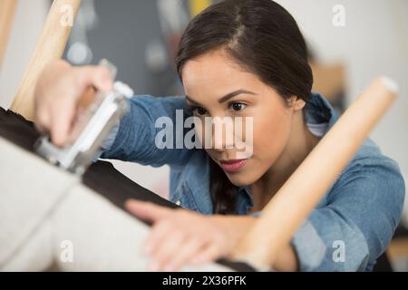 sedia da upcycling donna in officina a casa Foto Stock