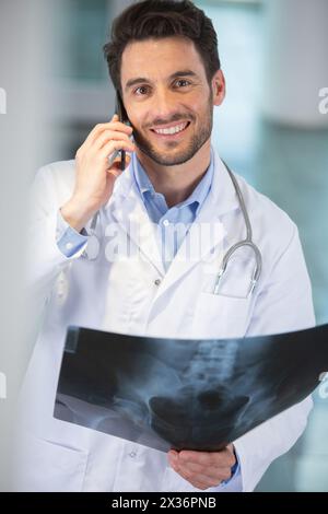 dottore al telefono con una xray Foto Stock