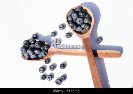 Frutti di bosco azzurri freschi su sppon di legno su sfondo bianco Foto Stock