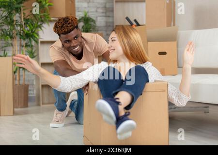 coppia mista che si diverte con i cartoni Foto Stock