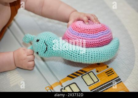 il bambino gioca con un giocattolo a maglia nella nursery Foto Stock