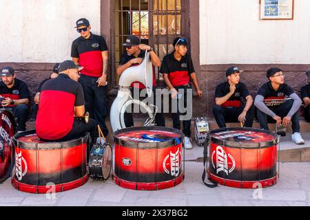 I musicisti riposano all'ombra prima di esibirsi a la Fiesta de la Virgen de la Candelaria, San Pedro de Atacama, regione di Antofagasta, Cile. Foto Stock