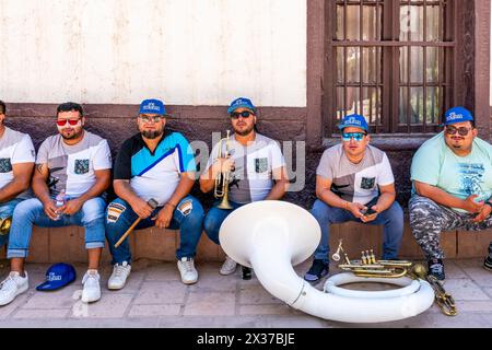 I musicisti riposano all'ombra prima di esibirsi a la Fiesta de la Virgen de la Candelaria, San Pedro de Atacama, regione di Antofagasta, Cile. Foto Stock