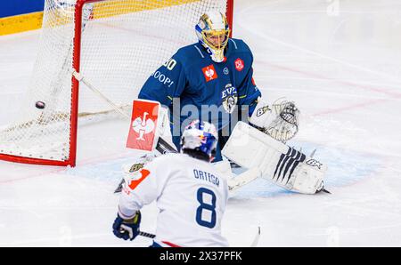 Zug Torhüter #30 Leonardo Genoni wehrt den Schuss des Münchner Stürmer #8 Austin Ortega seitlich ab. (Zugo, Svizzera, 23.11.2022) Foto Stock