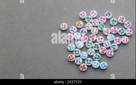 Perline decorative in plastica con volti divertenti. Pietre decorative bianche per la collana. Foto Stock