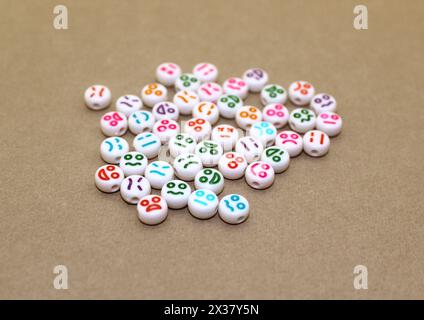 Perline decorative in plastica con volti divertenti. Pietre decorative bianche per la collana. Foto Stock