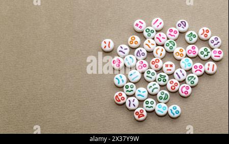 Perline decorative in plastica con volti divertenti. Pietre decorative bianche per la collana. Foto Stock