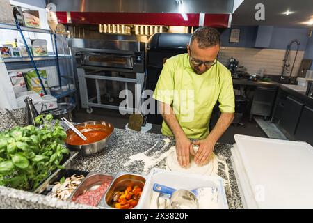 chef che prepara l'impasto per preparare la pizza, cucina del ristorante. Foto di alta qualità Foto Stock