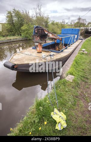 Imbarcazione per la manutenzione dotata di una gru (Atlas 3008) e di un'area di cassone profondo e vuoto in cui è possibile mettere in sicurezza i depositi canale di Leeds e Liverpool vicino a Gargrave, Foto Stock