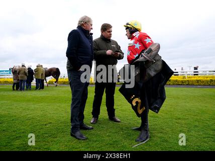 Jockey Harry Skelton parla con suo padre Nick Skelton (a sinistra) e con l'allenatore e fratello Dan Skelton all'ippodromo di Warwick. Data foto: Giovedì 25 aprile 2024. Foto Stock