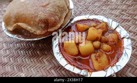 Gustosi Bedmi Puri con Aloo ki sabzi serviti in ciotola. Colazione dall'India Foto Stock