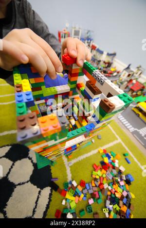 MOSCA - DEC 5, 2016: Mani di ragazzo che giocano con il set di erettori colorati Lego, la società LEGO Group è stata fondata nel 1932 Foto Stock