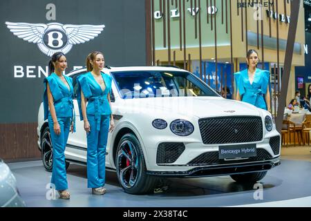 Lussuosa auto ibrida bianca Bentley Bentayga tre bellissimi modelli per ragazze. Thailandia, Bangkok, 07 aprile 2024. Foto Stock