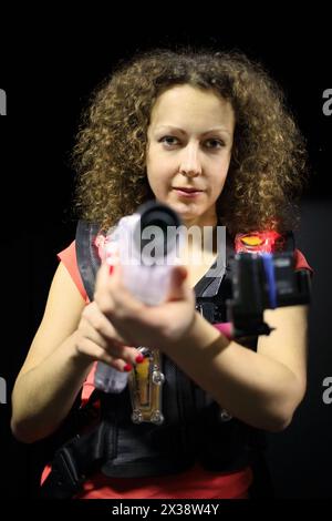 MOSCA - 13 dicembre 2014: Donna con capelli ricci (con rilascio del modello) in un gilet speciale con una pistola laser in laser tag presso il centro commerciale Capitol Verna Foto Stock