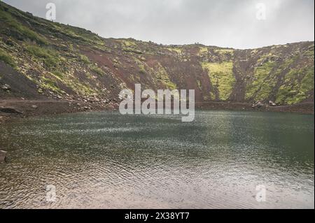 Lago del cratere islandese Kerið in condizioni di nebbia e pioggia Foto Stock