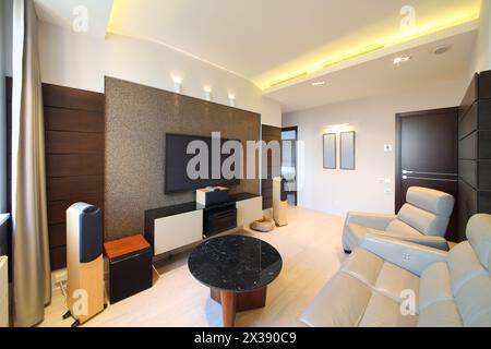 Interni di un moderno soggiorno con home Theatre e divano e poltrona in pelle Foto Stock