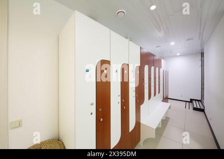 Molti armadietti in legno per i vestiti in una stanza vuota nel centro fitness Foto Stock